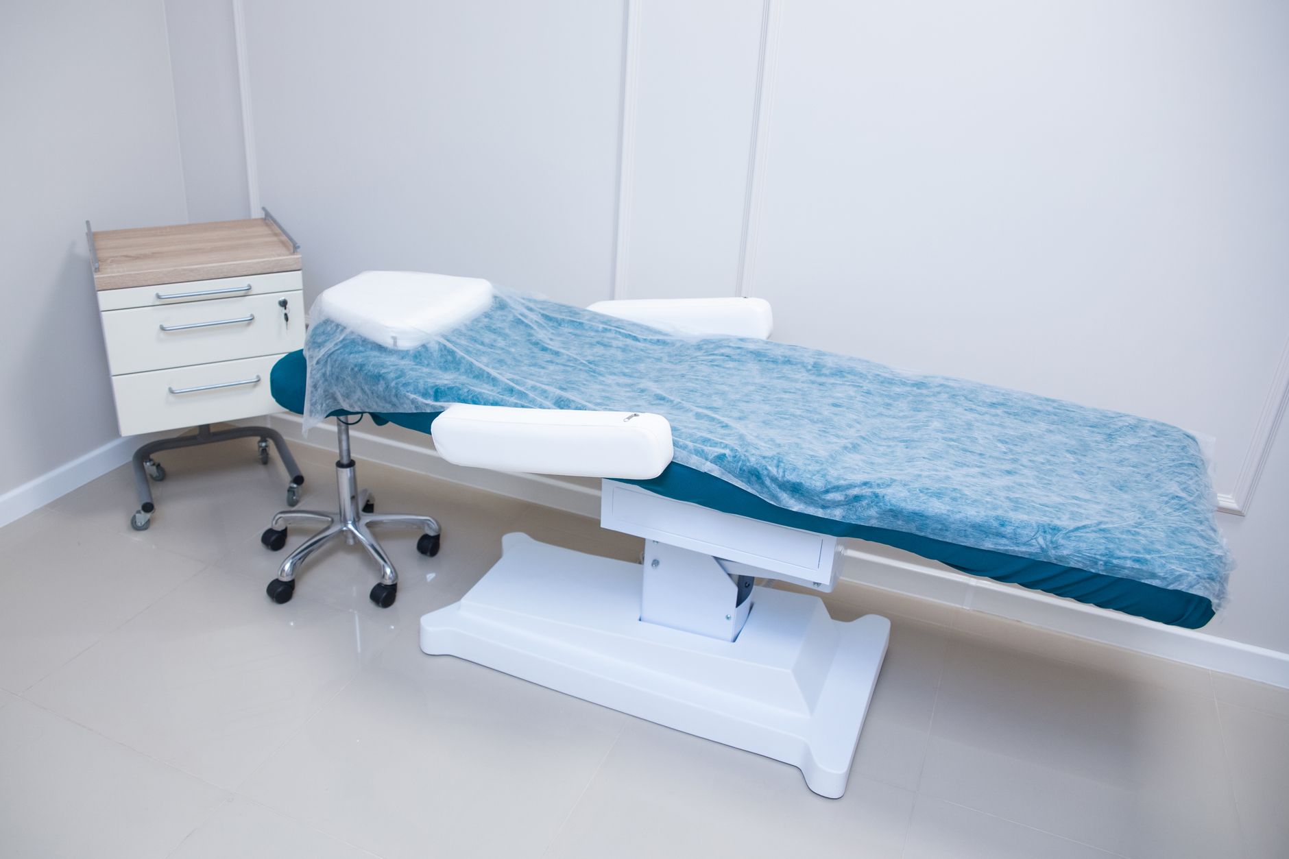 modern medical examination room with adjustable examination table and medical tools