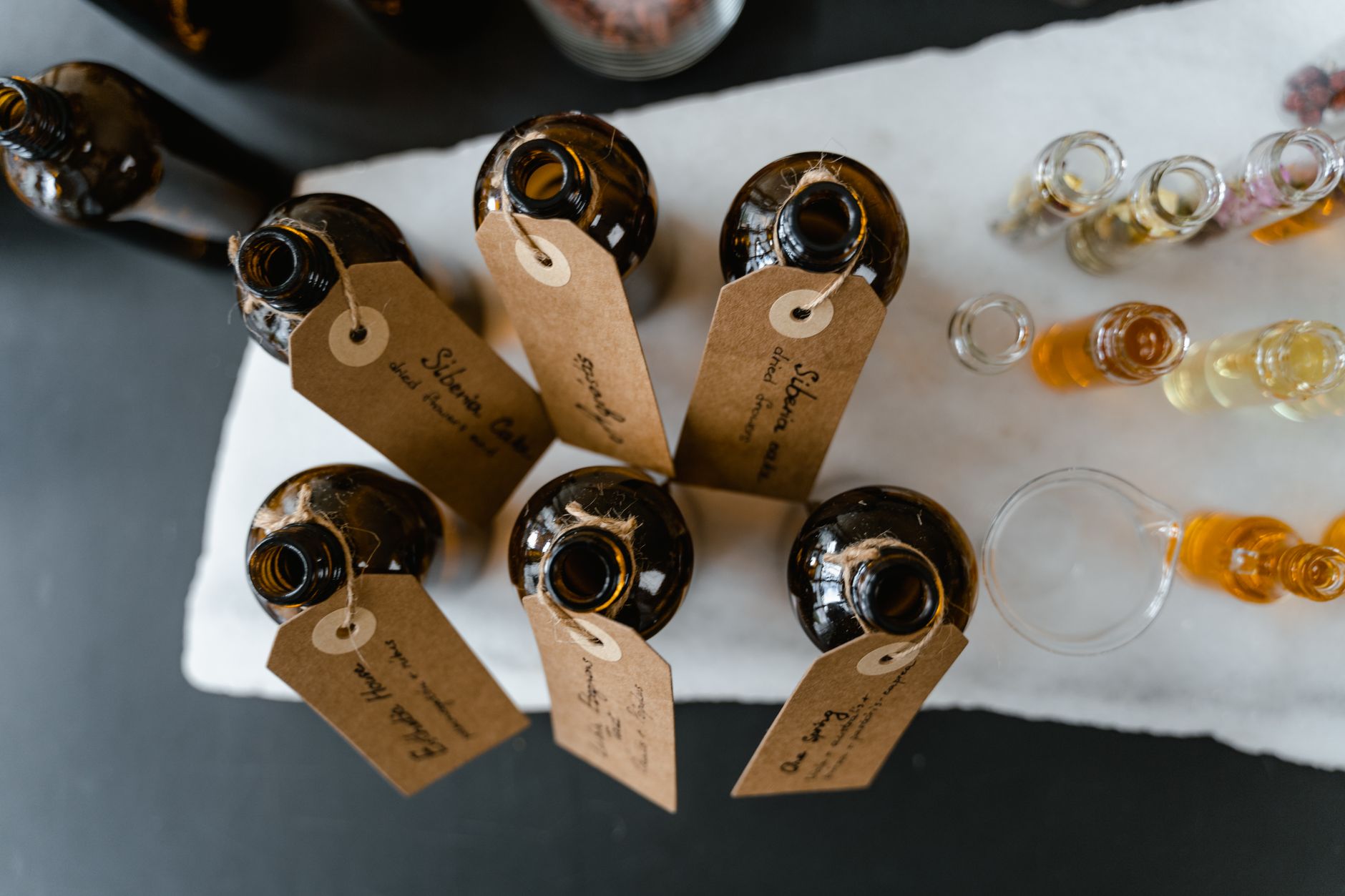 various glass bottles with essential oils and natural ingredients on a wooden table