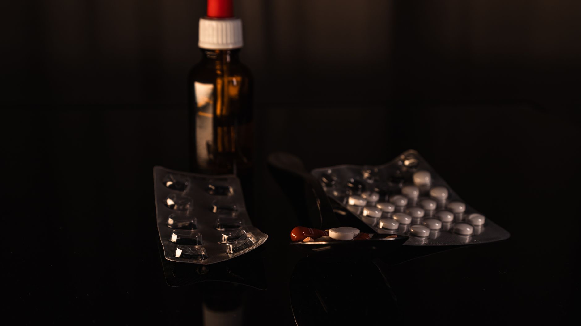 various herbal supplements in glass bottles and blister packs on a clean white background, natural light